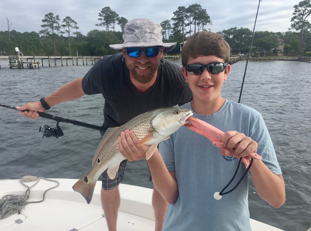 two boys holding a speckled trout